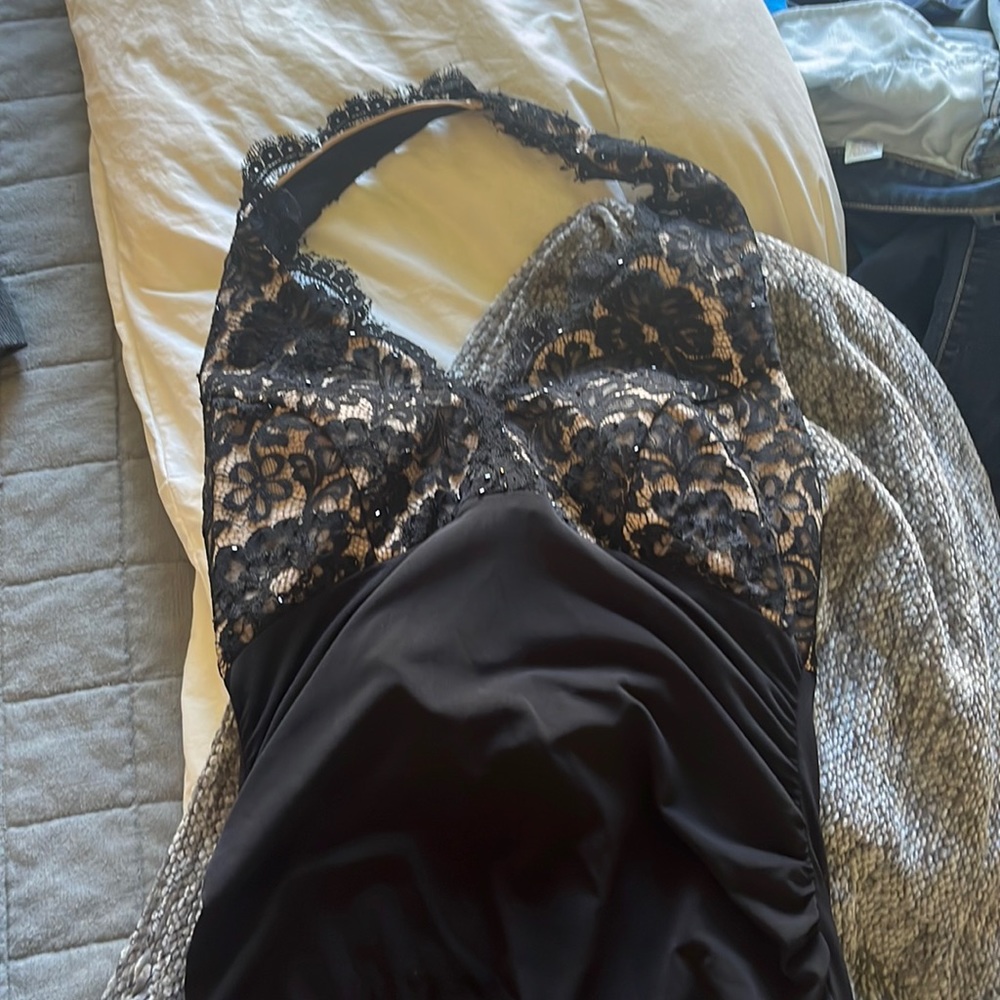 Black halter top dress with netting on chest and tan fabric behind netting